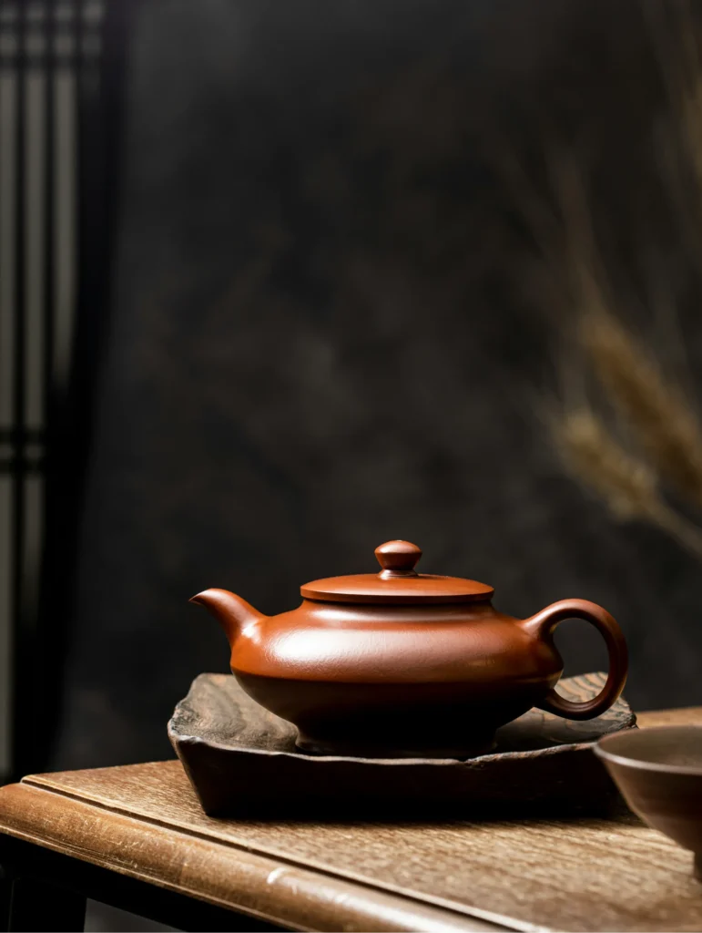 Brown ceramic teapot on a wooden tea table