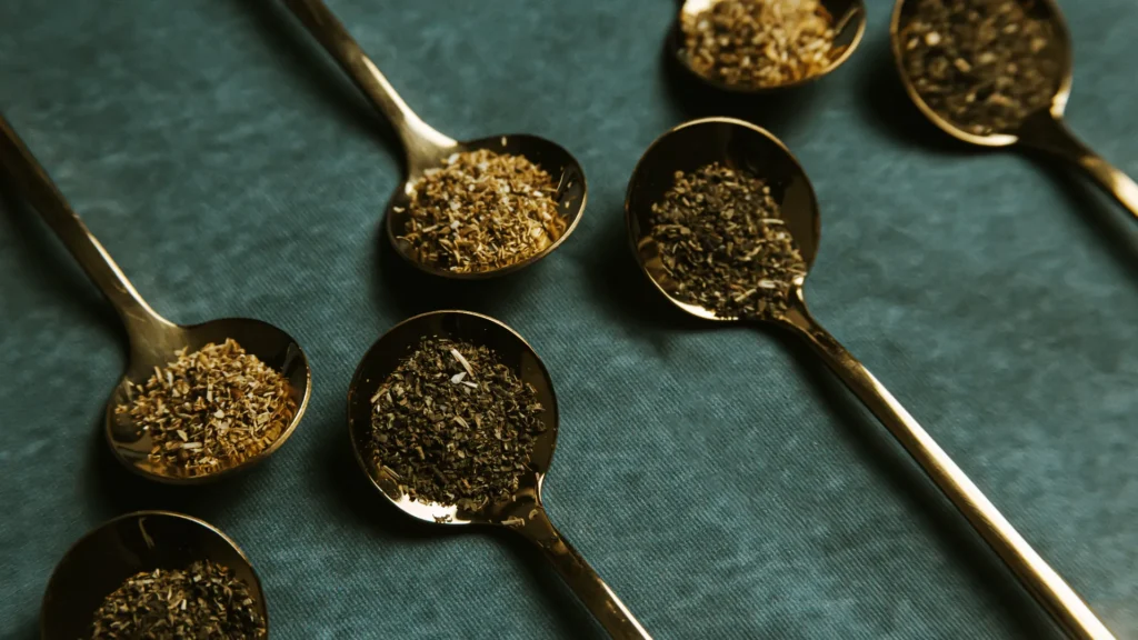 Gold spoons filled with loose leaf tea