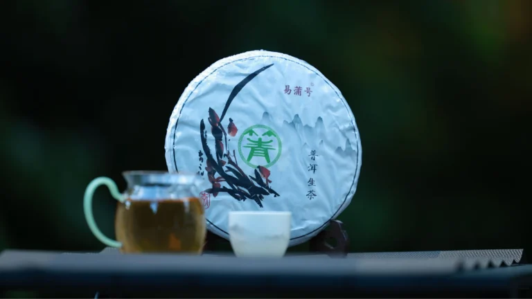 A compressed pu-erh tea cake next to a freshly brewed cup of tea, ready to be steeped multiple times.