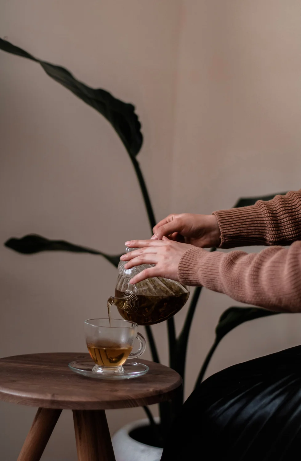 Tea being poured into a cup Tea being poured from a glass teapot into a cup